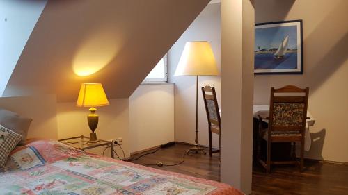 陶努斯的孔宁斯泰因Penthouse Zimmer mit Bad EM2024 Hospitality Package的一间卧室配有一张床、一盏灯和一把椅子