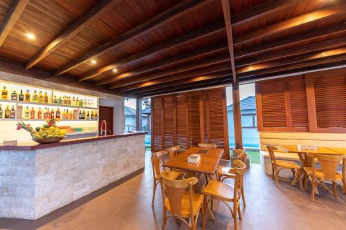 圣米格尔-杜戈斯托苏AWARA POUSADA BOUTIQUE的餐厅设有酒吧和桌椅