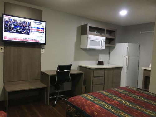 亨博尔旅游套房汽车旅馆的配有一张床和一台平面电视的酒店客房