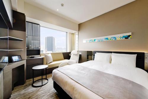 东京remm plus Ginza的酒店客房,配有床和沙发