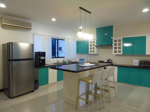 斯里巴加湾市Rimbun Suites & Residences的厨房配有绿色橱柜和不锈钢冰箱