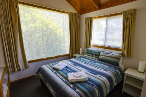Beauty Point美丽景点观光假日公园的一间卧室配有带毛巾的床