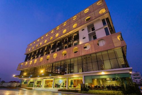 罗勇Hotel Fuse Rayong的一座高大的建筑,有很多窗户