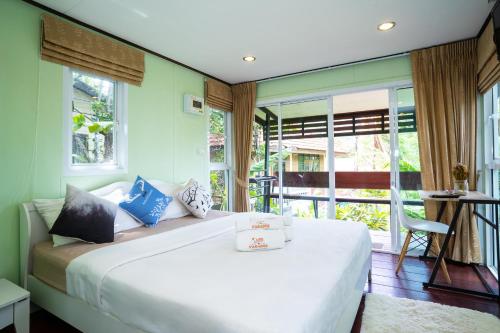 哈林海滩Hill Zone Home Stay by Little Paradise的一间带一张白色大床的卧室和一个阳台