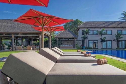 太平洋港Villa Takali - CFC Certified的一座带游泳池和红伞的房子