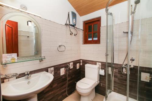 努沃勒埃利耶Thilina Hotel的浴室配有卫生间、盥洗盆和淋浴。