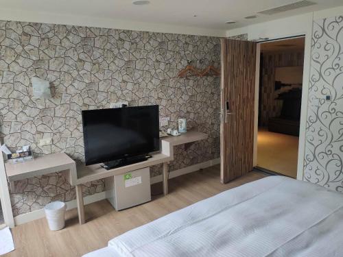 基隆恆昌商旅的卧室配有壁挂式平面电视