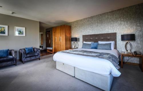 戈尔韦猎人旅馆的一间大卧室,配有一张大床和两把椅子