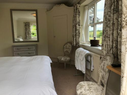 安德沃Staggs Cottage的一间卧室配有一张床、镜子和窗户
