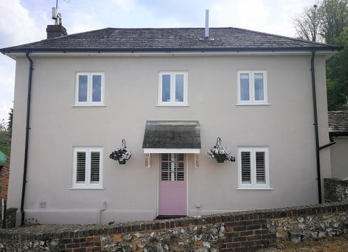 安德沃Staggs Cottage的白色的房子,有粉红色的门