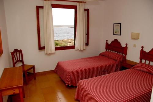 蓬塔格罗萨洛克斯码头公寓的酒店客房设有两张床和窗户。