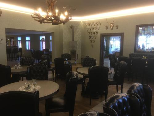 塔勒阿克森特贝尔罗斯塔普酒店的一间带桌椅和吊灯的用餐室