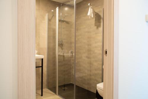 蒙蒂霍Hotel Gran Sol De Extremadura的浴室里设有玻璃门淋浴