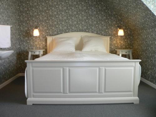 赛比Riverside Voerså的卧室配有白色的床和两张桌子
