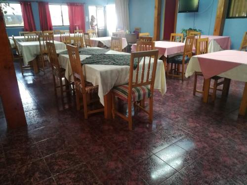 孔斯蒂图西翁Hostal Casona del Cerro的用餐室配有桌椅和白色的桌布