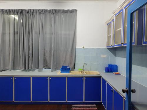 哥打巴鲁ALA Beach Lodge - Ketapang Homestay的厨房配有蓝色橱柜和水槽