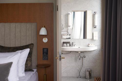 赫尔辛基赫尔辛基苏可酒店的卧室配有水槽和墙上的镜子