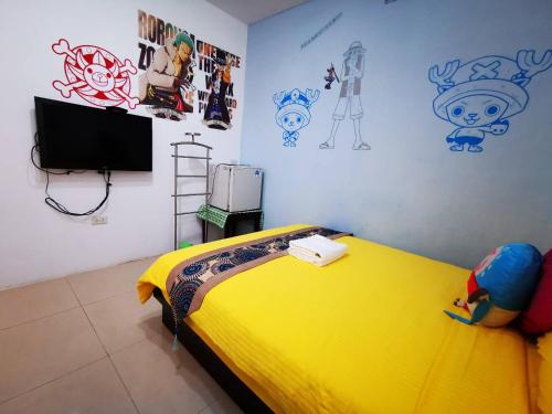 鹅銮鼻垦丁南点民宿的一间卧室配有一张黄色的床,墙上挂着一些图画