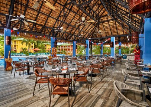 普拉亚布兰卡罗若迪卡若巴拿马度假村 - 全包的一间带桌椅的餐厅和一个游泳池