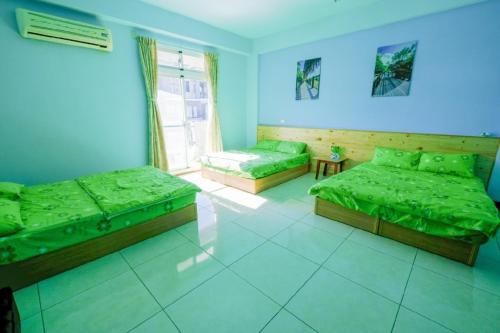 台东美泰の民宿的一间设有两张床和一张沙发的房间