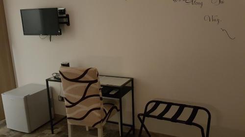 菲乌米奇诺THAT'S AMORE FIUMICINO Airport的一间带椅子和桌子的房间以及一台电视