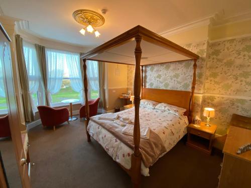 斯凯格内斯克拉伦斯酒店的一间卧室配有一张天蓬床和一张书桌