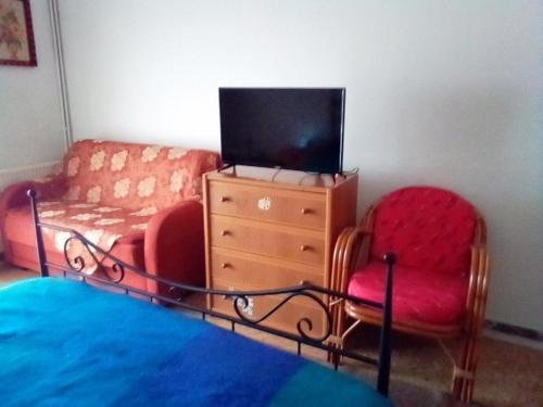 卢特拉艾季普苏Nikos Rooms的客厅配有沙发、电视和两把椅子