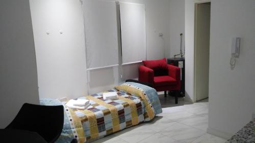 CaserosAloha VIII - Caseros的一间卧室配有一张床和一张红色椅子