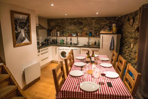 夏蒙尼-勃朗峰Prachtig familie appartement voor 6 personen in het hart van Argentière, Chamonix Mont-Blanc的厨房配有一张带红白桌布的桌子