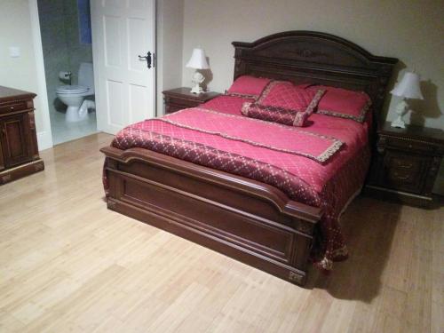 巴利纳斯洛Riverview Country House的卧室配有一张大床,提供红色床单和枕头