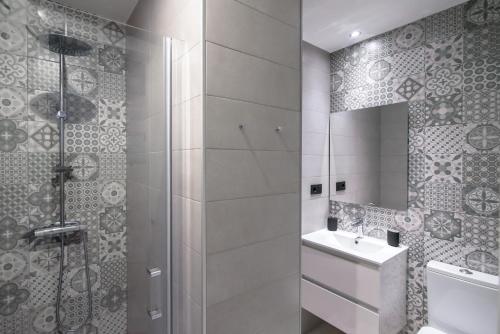 格拉纳达Granadi Apartamentos的带淋浴和盥洗盆的浴室
