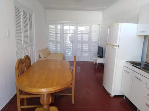 图蓬加托火山Departamento céntrico Tupungato的厨房配有木桌和冰箱。