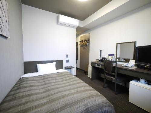 裾野市如特酒店 - 苏斯诺因特尔酒店的一间卧室配有一张床、一张桌子和一台电脑