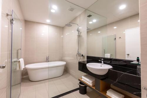 哥打京那巴鲁Hotel 7 Suria的带浴缸、盥洗盆和卫生间的浴室