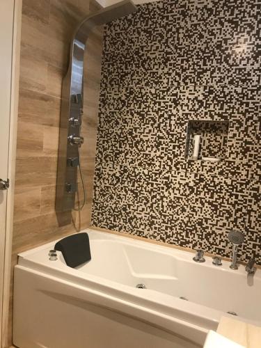 卡哈马卡SHINAWASIM的带浴缸的浴室和砖墙