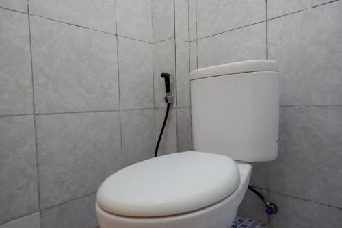 肯达利RedDoorz Syariah @ Hotel Wisma Indonesia Kendari的墙上设有白色卫生间的浴室