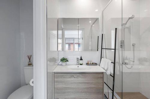 CarnegieHeart of Ormond Apartment by Ready Set Host的白色的浴室设有水槽和淋浴。