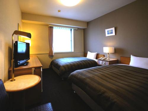 福山福山温泉格兰蒂亚路线度假酒店的酒店客房设有两张床和电视。