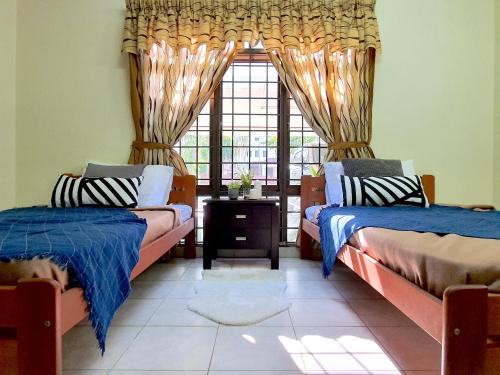 Kampong Alor GajahA famosa Resort Villa with private pool by BeeStay 10 pax的一间卧室设有两张床和窗户。