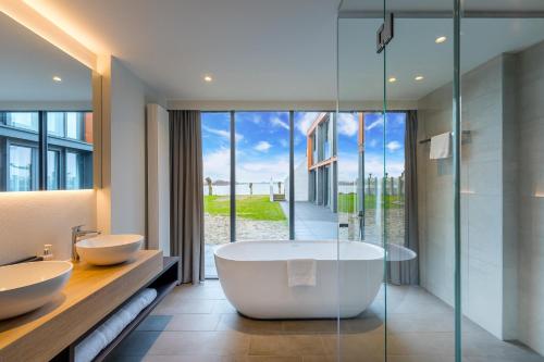 皮滕阿默斯福特费吕沃梅尔普斯提里翁酒店的浴室配有2个盥洗盆和1个浴缸。
