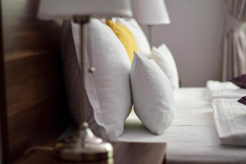 克卢日-纳波卡Cabrio Apart Hotel的床上一组枕头和一盏灯