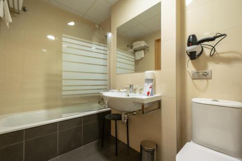 米兰达德埃布罗Hotel Abades Via Norte的一间带水槽、卫生间和镜子的浴室