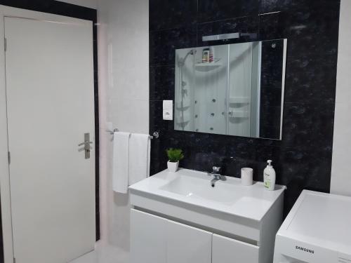 洛萨达Lemon Tree House的浴室设有白色水槽和镜子