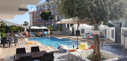 安塔利亚Esperanza Hotel的一个带桌椅的游泳池和一间酒店