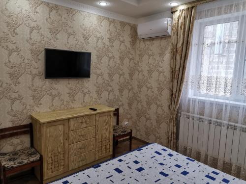 阿纳帕Holiday Home on Krasnozelenykh的卧室设有壁挂式电视和床。