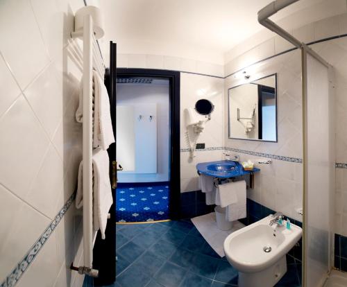 摩德纳伊斯坦斯酒店的蓝色和白色的浴室设有水槽和卫生间