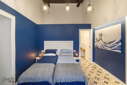 那不勒斯Le Chiavi di Casa的蓝色墙壁客房的两张床