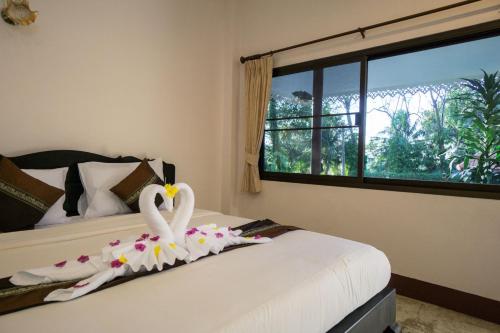 象岛张克里夫度假酒店的两个天鹅坐在卧室的床上