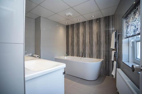 特伦特河畔斯托克博赫阿姆酒店的白色的浴室设有浴缸和水槽。