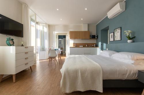 韦尔巴尼亚Aqualago casa vacanze apartment D的卧室配有白色的床和蓝色的墙壁